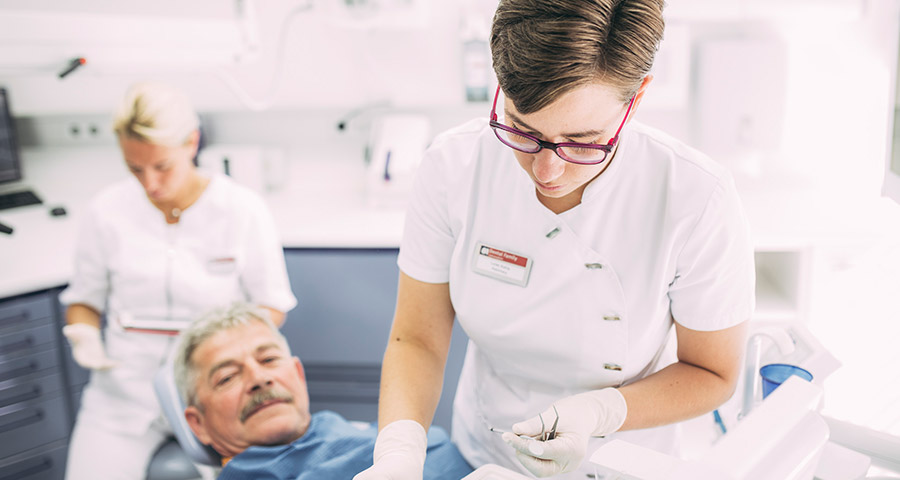 Mitarbeiterin bereitet Instrumente für Behandlung vor