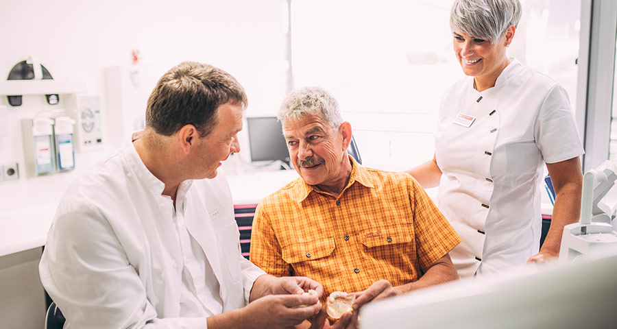 Dr. Andreas Pohl erklärt Patienten die Behandlungsmethode Feste Zähne